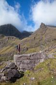 Hiker beneath Carrauntoohil from Lough Gouragh, MacGillycuddy's Reeks, County Kerry, Ireland.