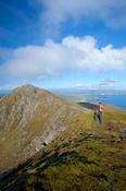 Walker near the summit of Croaghaun, Achill Island, Co Mayo, Ireland.