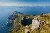 Walker looking towards Saddle Head from Croaghaun, Achill Island, Co Mayo, Ireland.