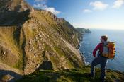 Walker beneath the western cliffs of Croaghaun, Achill Island, Co Mayo, Ireland.