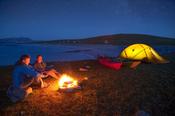 Sea kayakers enjoying an evening campfire, Inishkea South Island, County Mayo, Ireland.