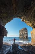 Person viewing Dun Briste sea stack from a cave beneath Downpatrick Head. County Mayo, Ireland. image