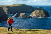 Walker in front of Kid Island, on the Children of Lir coastal walk. Carrowteige, County Mayo, Ireland.