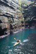 Sea kayaker in the cave beneath Downpatrick Head, Co Mayo, Ireland.