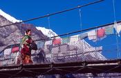 Local Nepali woman crossing a bridge on the Annapurna Circuit, Nepal.