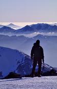 Walker looking towards Glencoe from the summit of Ben Nevis, Scotland.