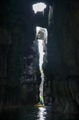 Sea kayaker in the chasm of Pollnashantunny, Inishmurray isalnd, County Sligo, Ireland.