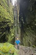 Hiker inside Annach Re Mhor chasm, Kings Mountain, County Sligo, Ireland.