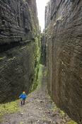 Hiker inside Annach Re Mhor chasm, Kings Mountain, County Sligo, Ireland.