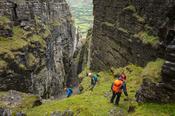 Hikers nearing the bottom of Annach Re Mhor chasm, Kings Mountain, County Sligo, Ireland.