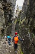 Hikers nearing the bottom of Annach Re Mhor chasm, Kings Mountain, County Sligo, Ireland.