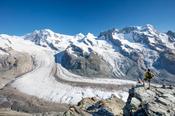 Hiker beside Gorner Glacier and Monte Rosa, Gornergrat, Zermatt, Switzerland.