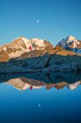 Reflection of hiker beneath Piz Bernina and Piz Rosbeg, Fuorcla Surlej, Berniner Alps, Graubunden, Switzerland.