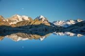 Reflection of moonrise over Piz Bernina and Piz Rosbeg, Fuorcla Surlej, Berniner Alps, Graubunden, Switzerland.