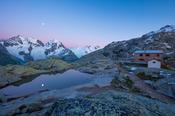 Moonrise over Piz Bernina and Fuorcla Surlej refuge, Berniner Alps, Graubunden, Switzerland.