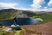 Walker admiring the view over Lough Tay, Wicklow Mountains, Co Wicklow, Ireland.
