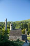 Visitors beneath St Kevin's church and round tower, Glendalough monastic site, Co Wicklow, Ireland.