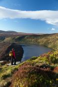 Walker looking over Lough Bray Upper, Wicklow Mountains National Park, County Wicklow, Ireland.