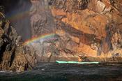 Sea kayaker beside a blow-hole rainbow, Arranmore Island, County Donegal, Ireland. image