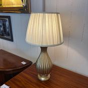 Classic gilt painted table lamp with an elegant, ribbed base and a soft, pleated image