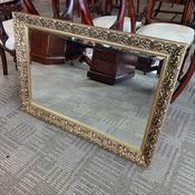 rectangular wall mirror featuring a beautifully decorative gold-finish frame