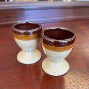 A pair of vintage 1970s stoneware egg cups with a brown and beige two-tone image
